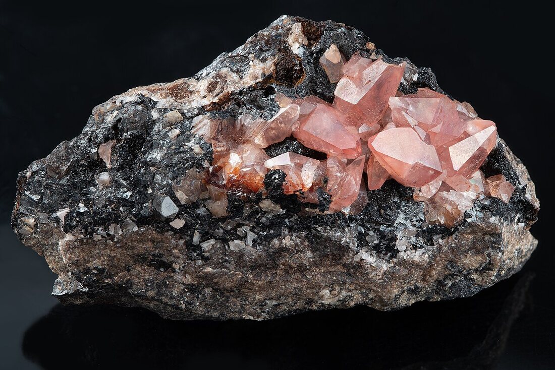 Rhodochrosite specimen — raspberry-red rhombohedra on matrix
